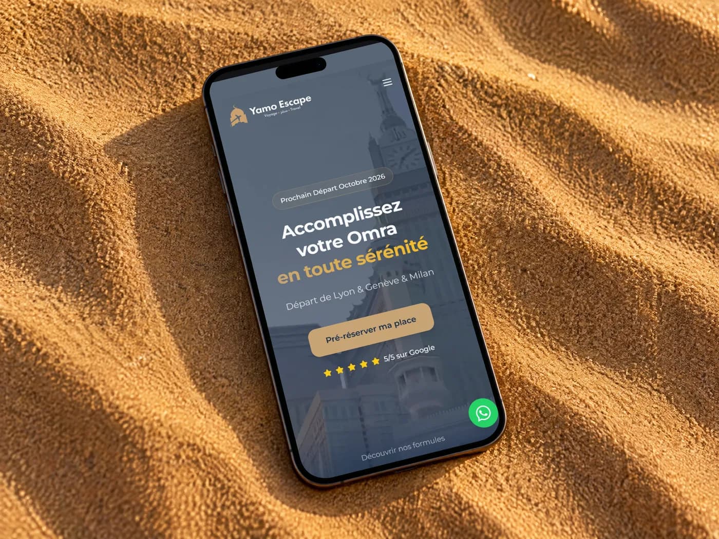 Le site de l'agence de omra Yamo Escape sur un téléphone posé sur le sable